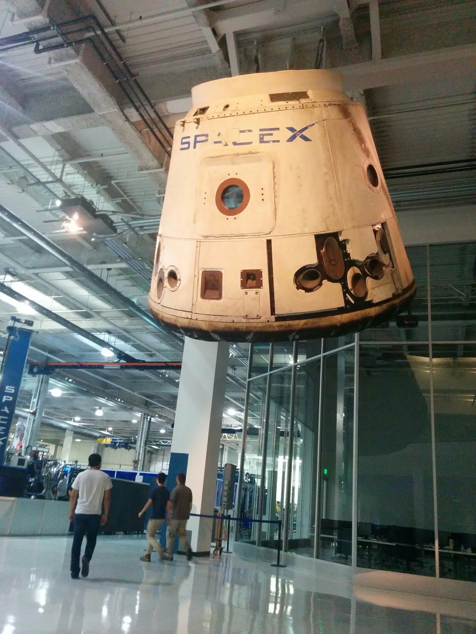 A flown Dragon capsule, scorched from re-entry, hanging in the SpaceX lobby in Hawthorne.